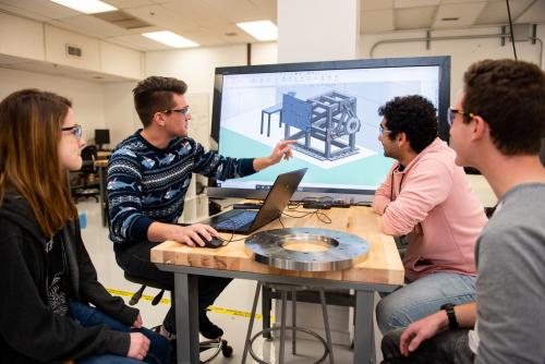 Students in lab pointing to a screen