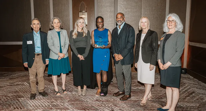 Award winner and individuals congratulating her